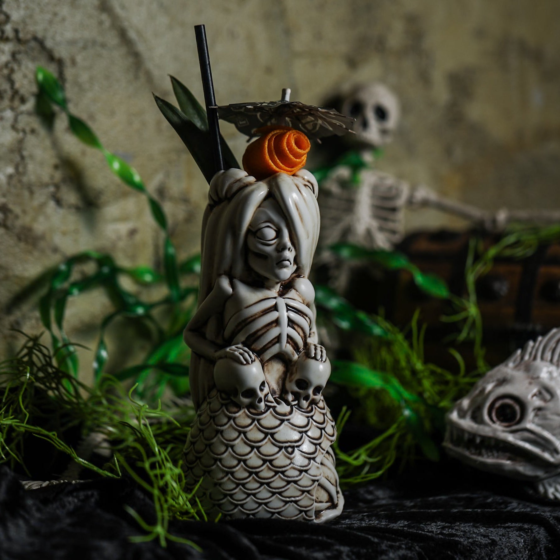 Spooky Zombie Mermaid Tiki Mug with skeleton design, in a dark bar setting